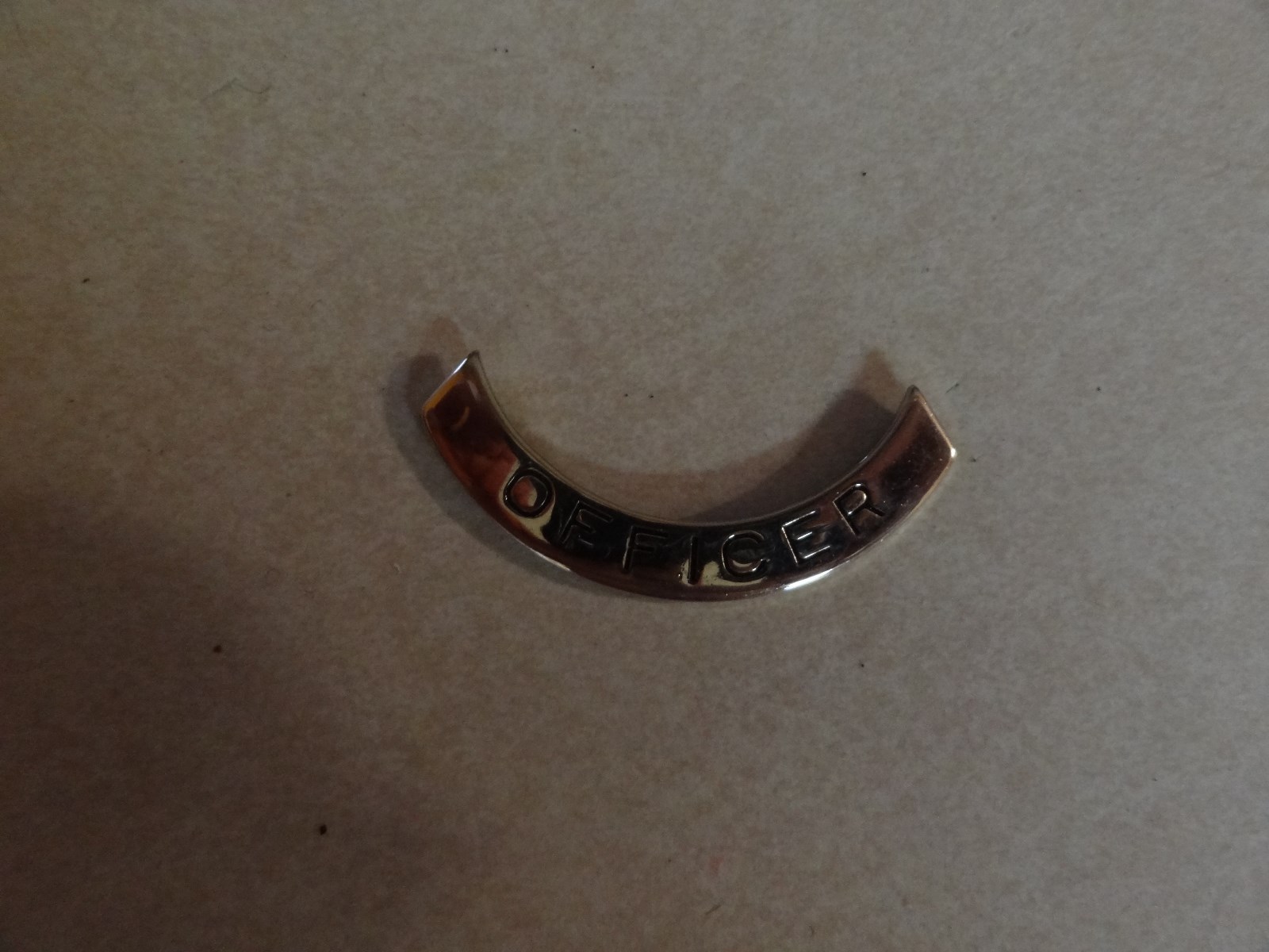 INSIGNIA TAB THAT CAN BE ADDED TO THE UNIFORM THAT SAYS OFFICER