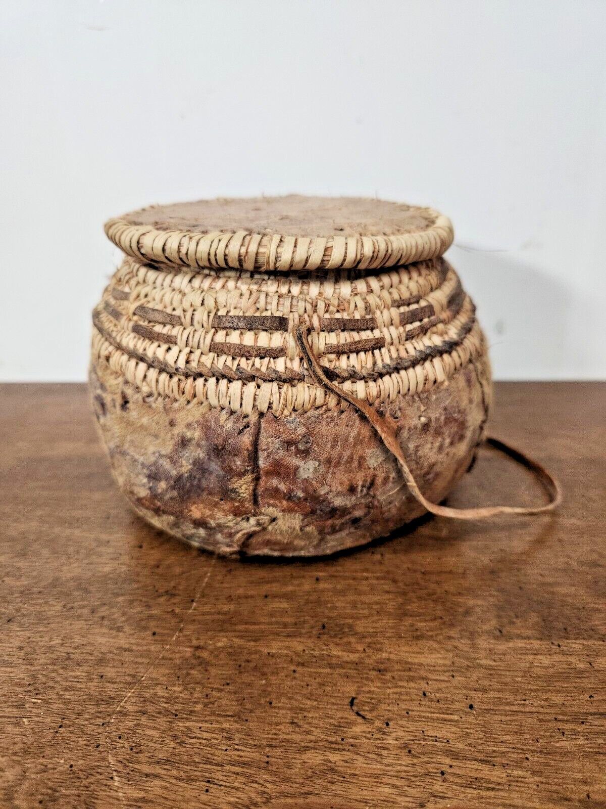 ANTIQUE OMANI BEDOUIN WOVEN LIDDED BASKET WITH LEATHER