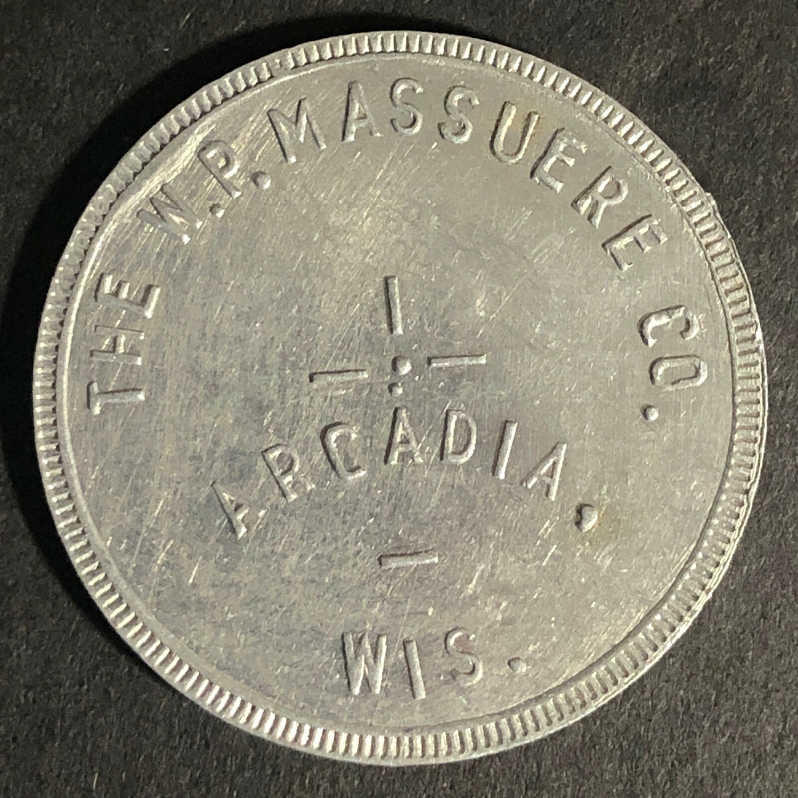The W.P. Massuere Co. Arcadia, WI  Alum. Token G/F $1 in Merchandise 31mm